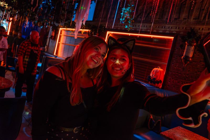 Two friends taking a selfie in a red-lit bar