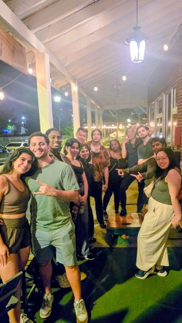 A crowd mingling on a covered patio at night