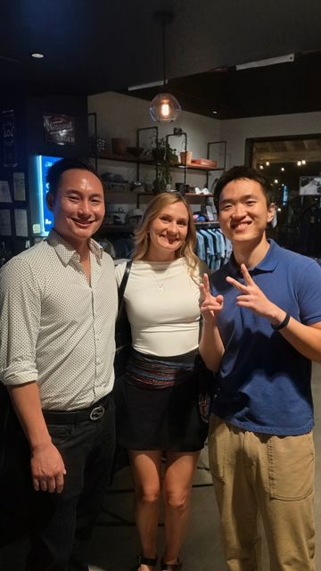 Three friends posing together inside a lounge