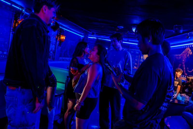 Guests chatting in a dim blue lounge
