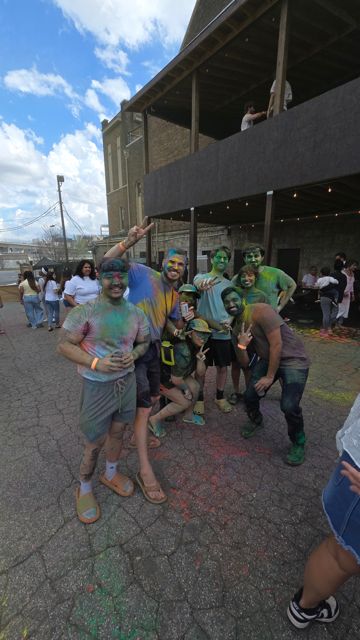 The group posing in the street after a Holi color party