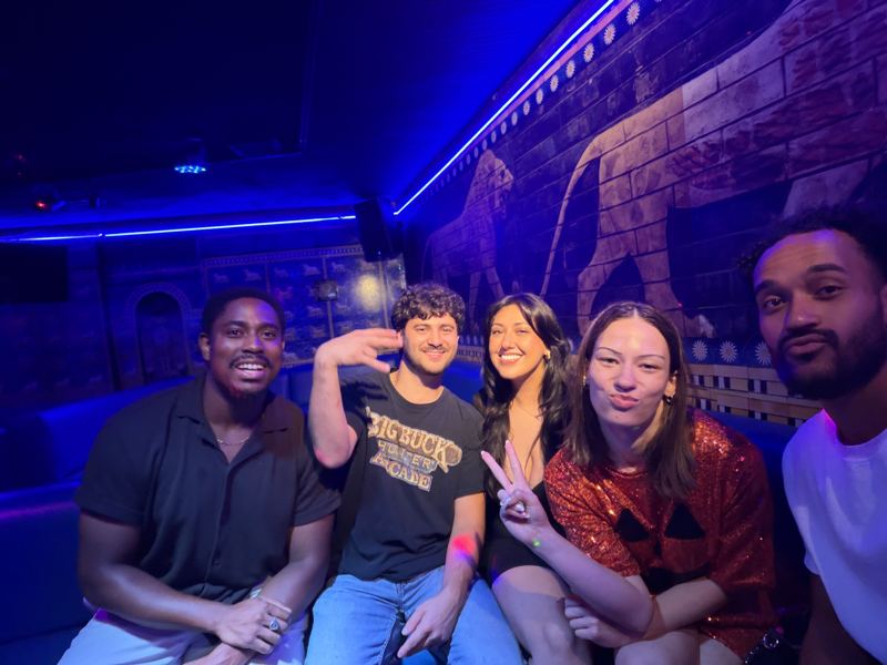 Five friends sitting together in a blue-lit room