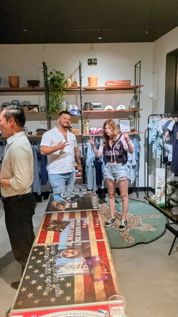 Guests playing a drinking game at a party in a shop