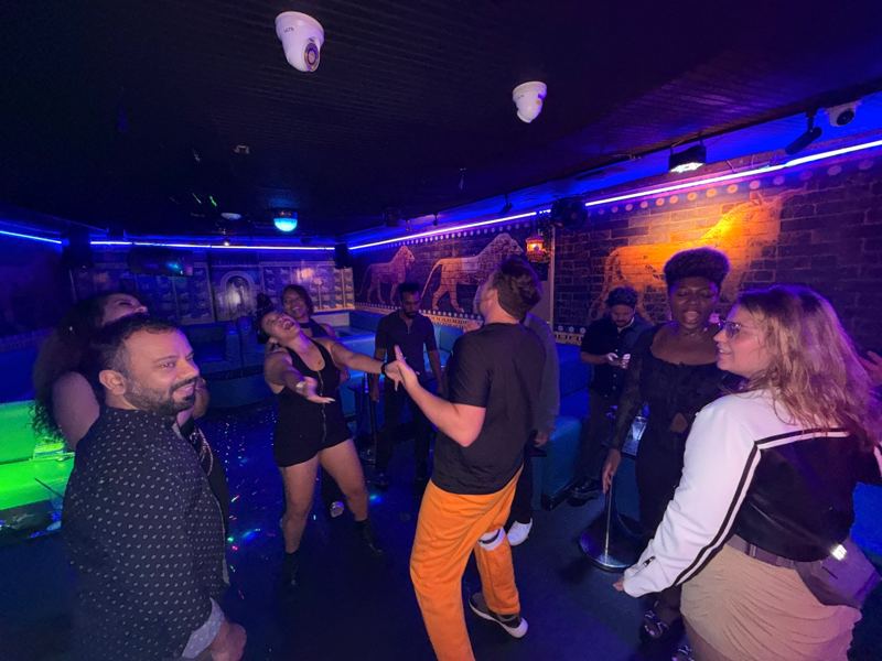People dancing in a lounge with blue neon lights