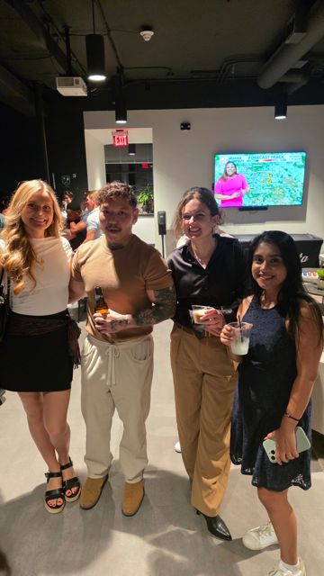 Four friends posing together at an evening party