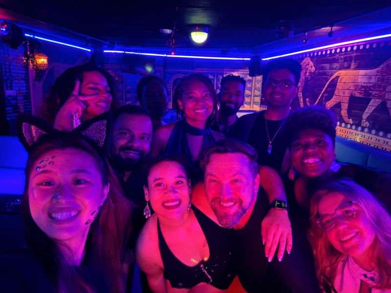 A close group selfie of smiling friends in a lounge