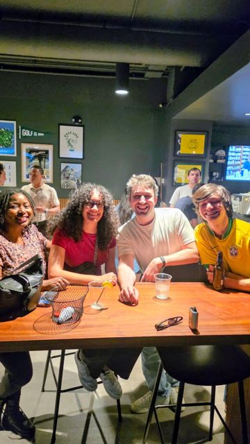 Friends sitting around a long table at a bar